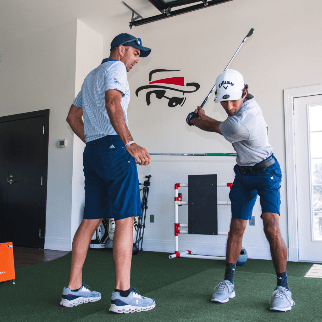 A junior golf camp student receives 1 on 1 attention from a coach