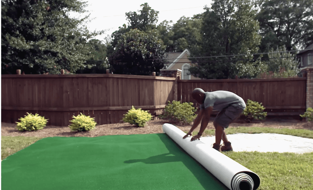 How to make a putting green: roll out the artificial turf over the prepared base